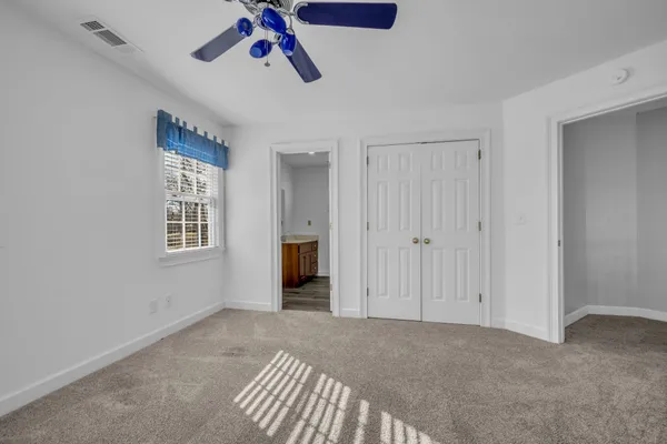 a view of a livingroom with a ceiling fan and window