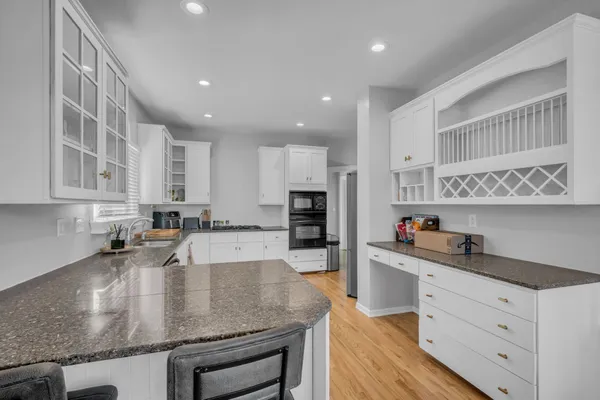 a kitchen with stainless steel appliances granite countertop a sink dishwasher and cabinets with wooden floor