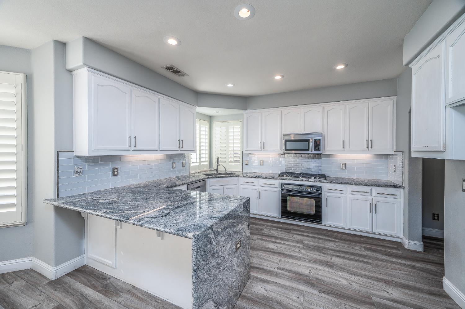 2800 Olympus Court Modesto, CA 95356 - Photo 3 of 56 a kitchen with stainless steel appliances granite countertop a stove top oven a sink dishwasher and a refrigerator with wooden floor