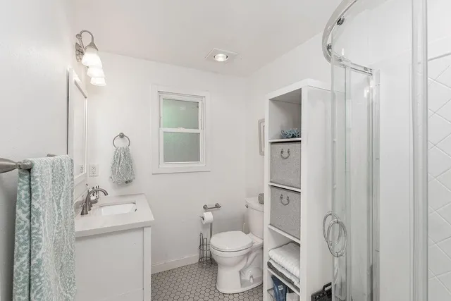 a bathroom with a granite countertop toilet sink and mirror