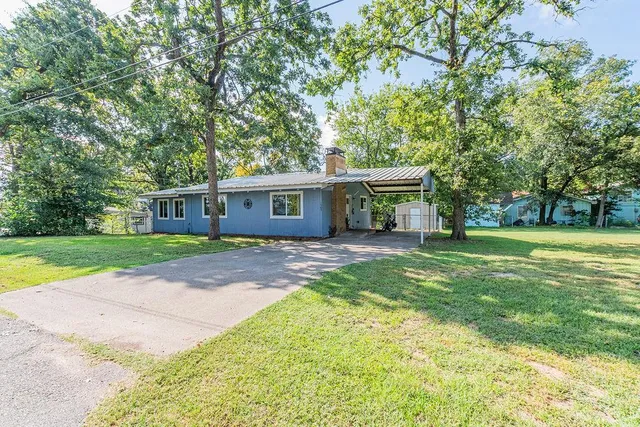 a view of a house with a yard and tree s