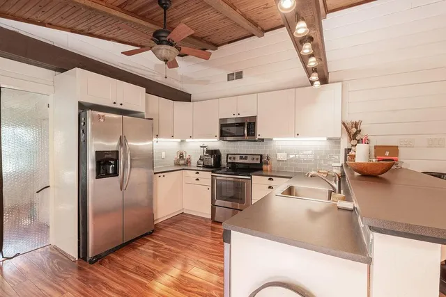 a kitchen with microwave a refrigerator and a sink