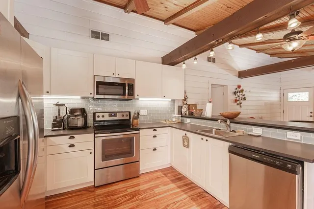 a kitchen with a sink stainless steel appliances and white cabinets