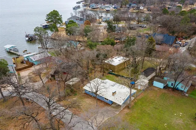 an aerial view of a house with a yard and lake view