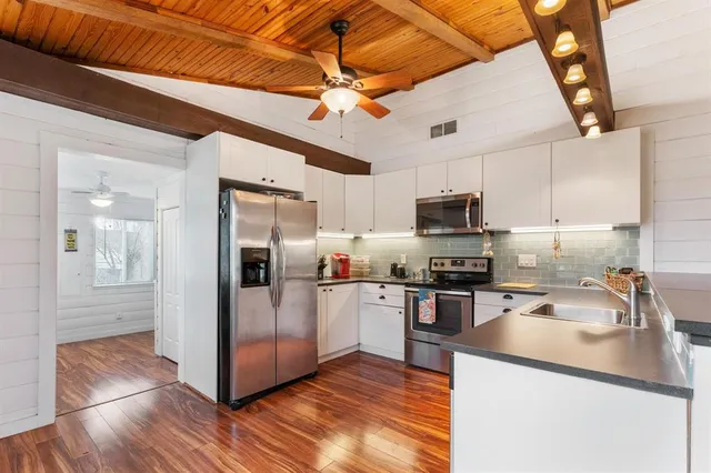 a kitchen with stainless steel appliances granite countertop a refrigerator a sink and dishwasher