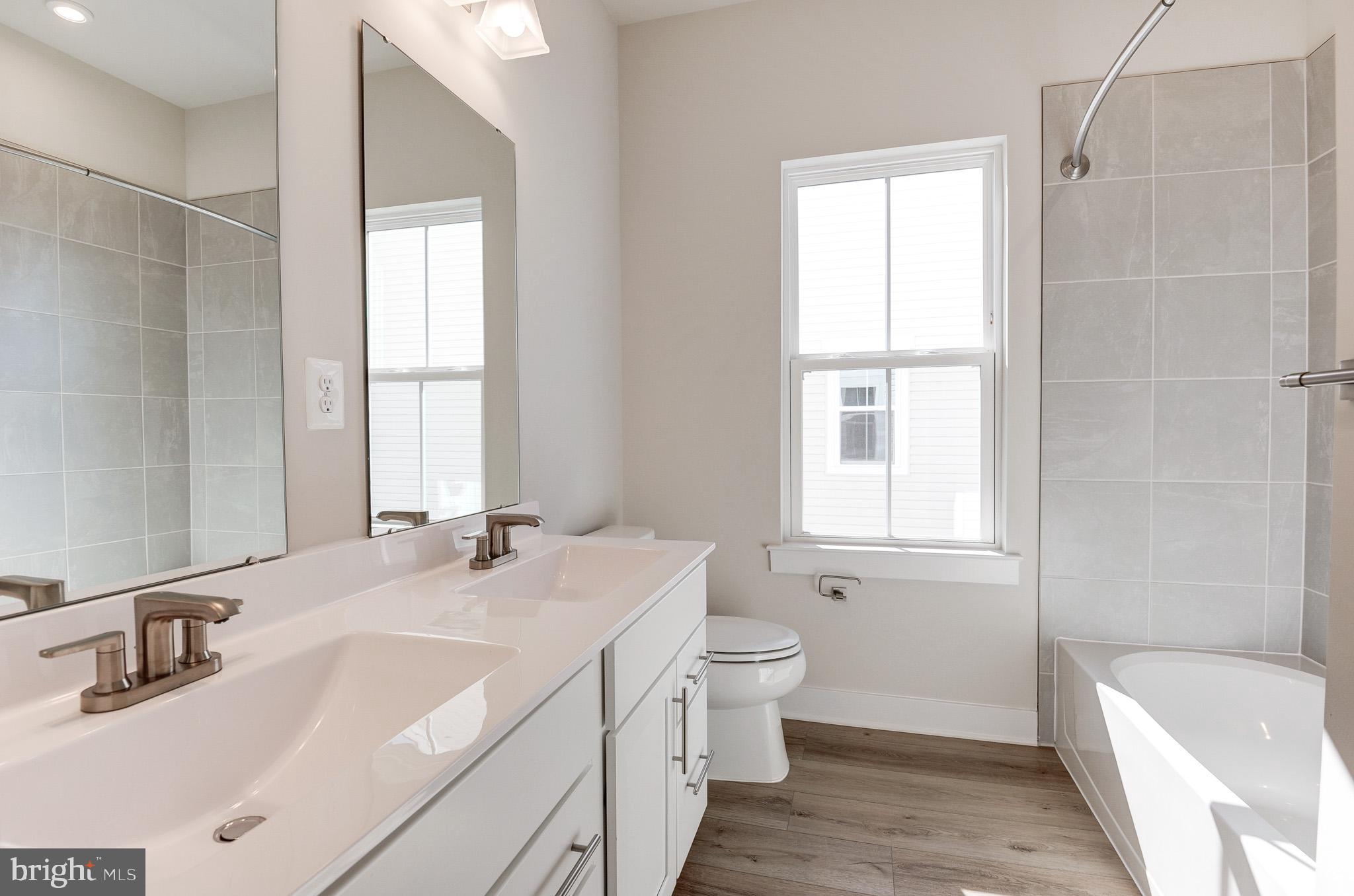 8020 Williamson Boulevard Manassas, VA 20109 - Photo 43 of 53 a bathroom with a double vanity sink a toilet and a tub