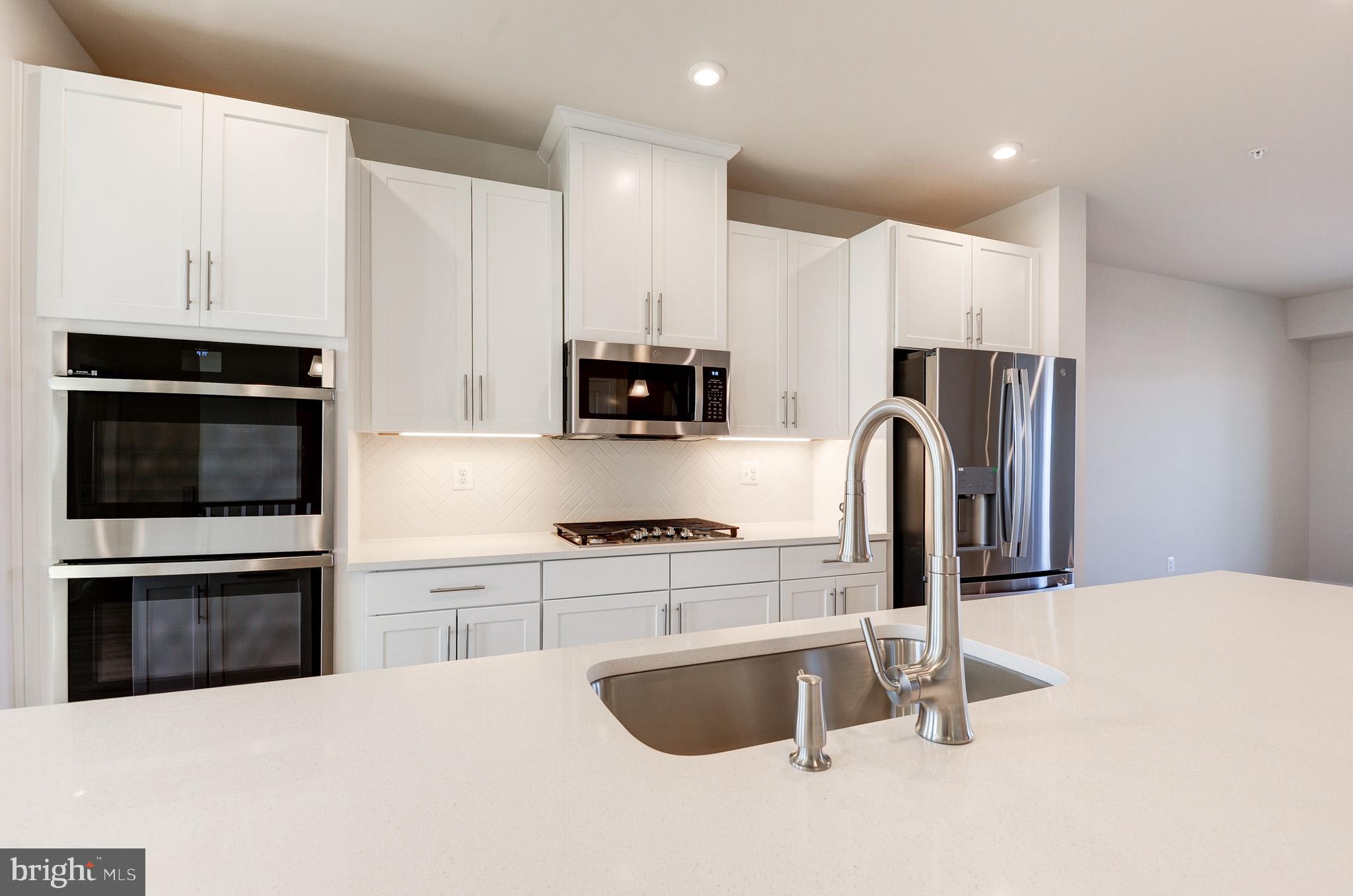 8020 Williamson Boulevard Manassas, VA 20109 - Photo 8 of 53 a kitchen with stainless steel appliances granite countertop a stove a sink and a refrigerator