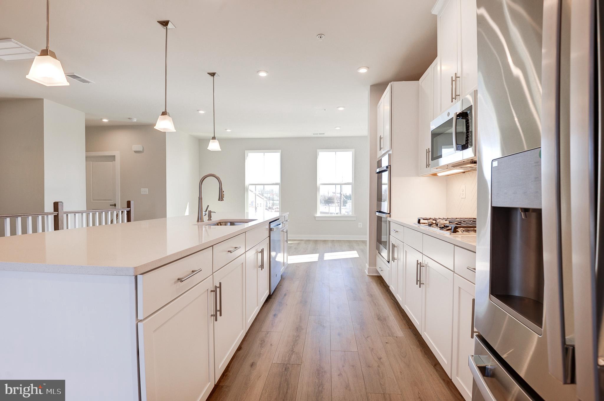 8020 Williamson Boulevard Manassas, VA 20109 - Photo 10 of 53 a large kitchen with stainless steel appliances a lot of counter space and a wooden floor