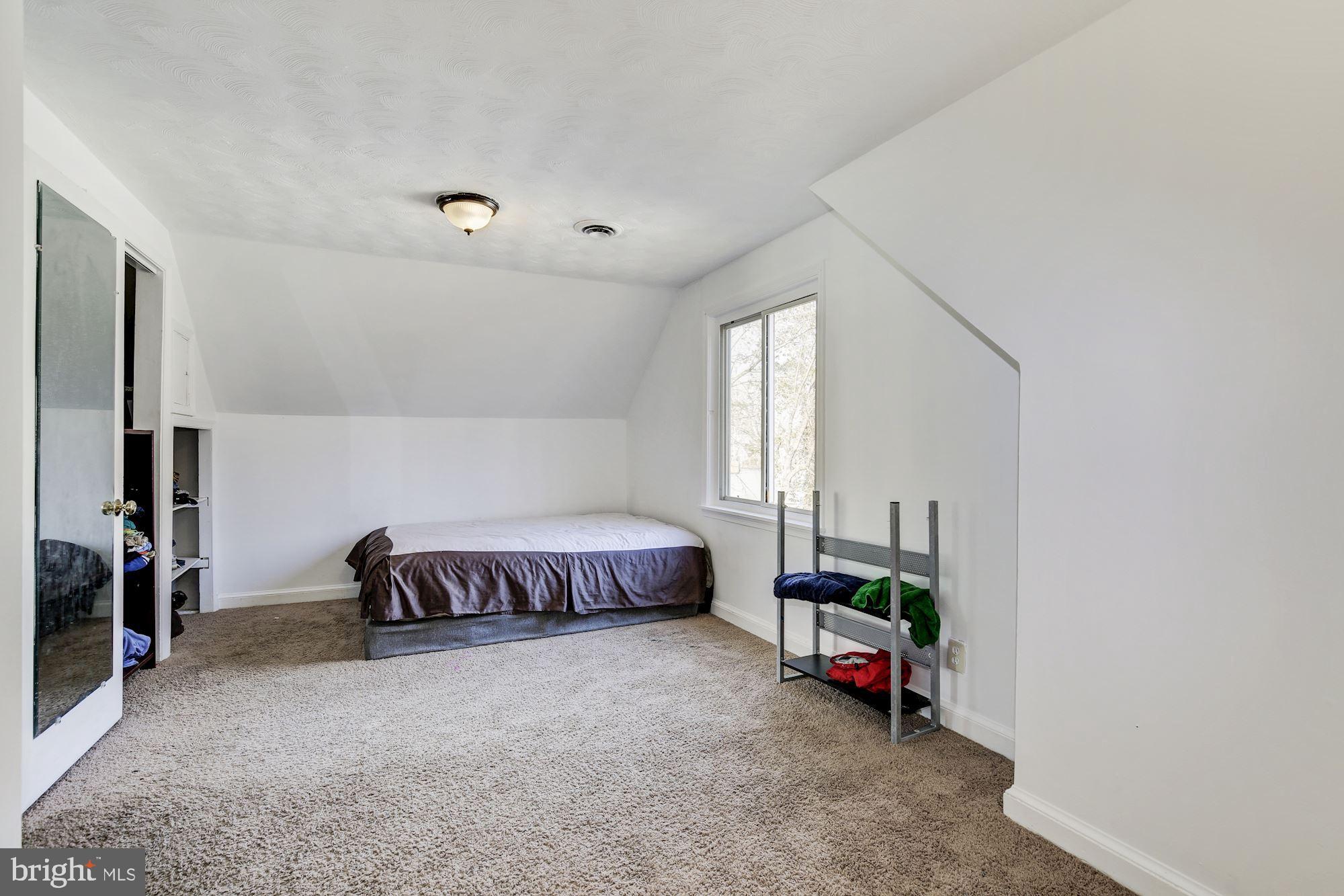 5705 Denfield Road Rockville, MD 20851 - Photo 13 of 20 a living room with a bed furniture and a window