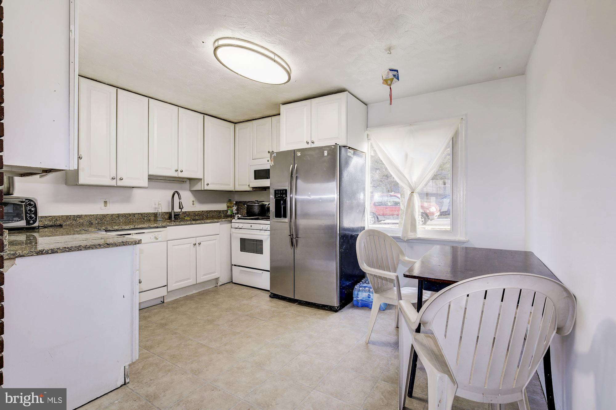 5705 Denfield Road Rockville, MD 20851 - Photo 7 of 20 a kitchen with refrigerator cabinets and wooden floor