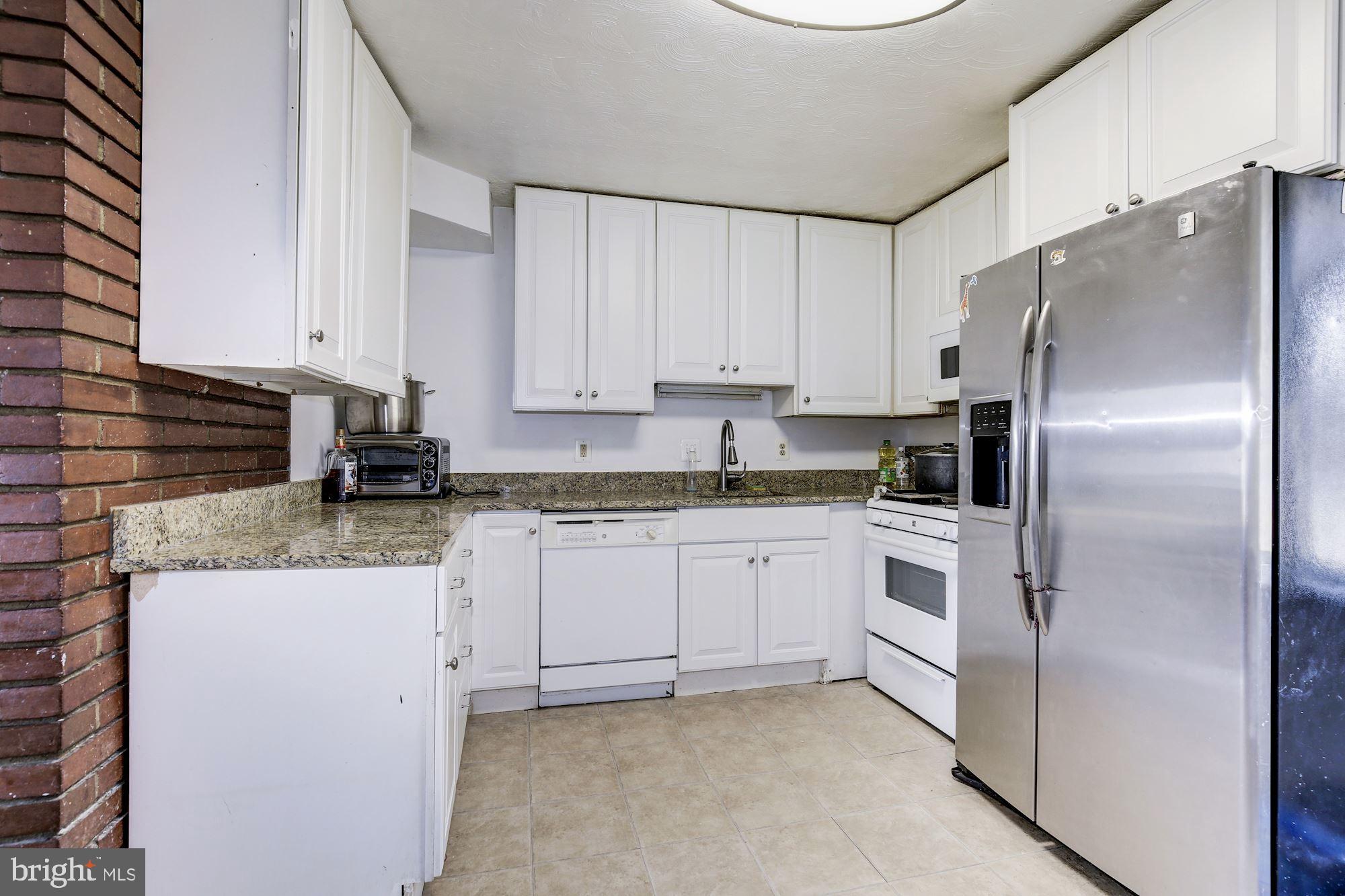 5705 Denfield Road Rockville, MD 20851 - Photo 8 of 20 a kitchen with stainless steel appliances granite countertop a refrigerator sink and white cabinets