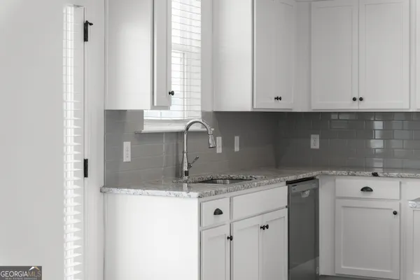 a kitchen with granite countertop a sink and cabinets