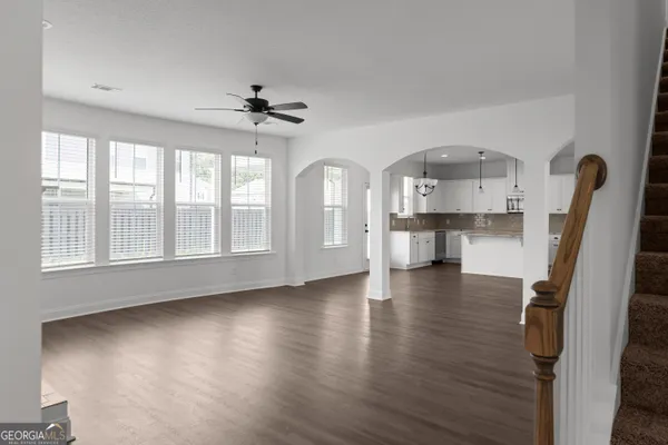 a view of empty room with a kitchen and wooden floor