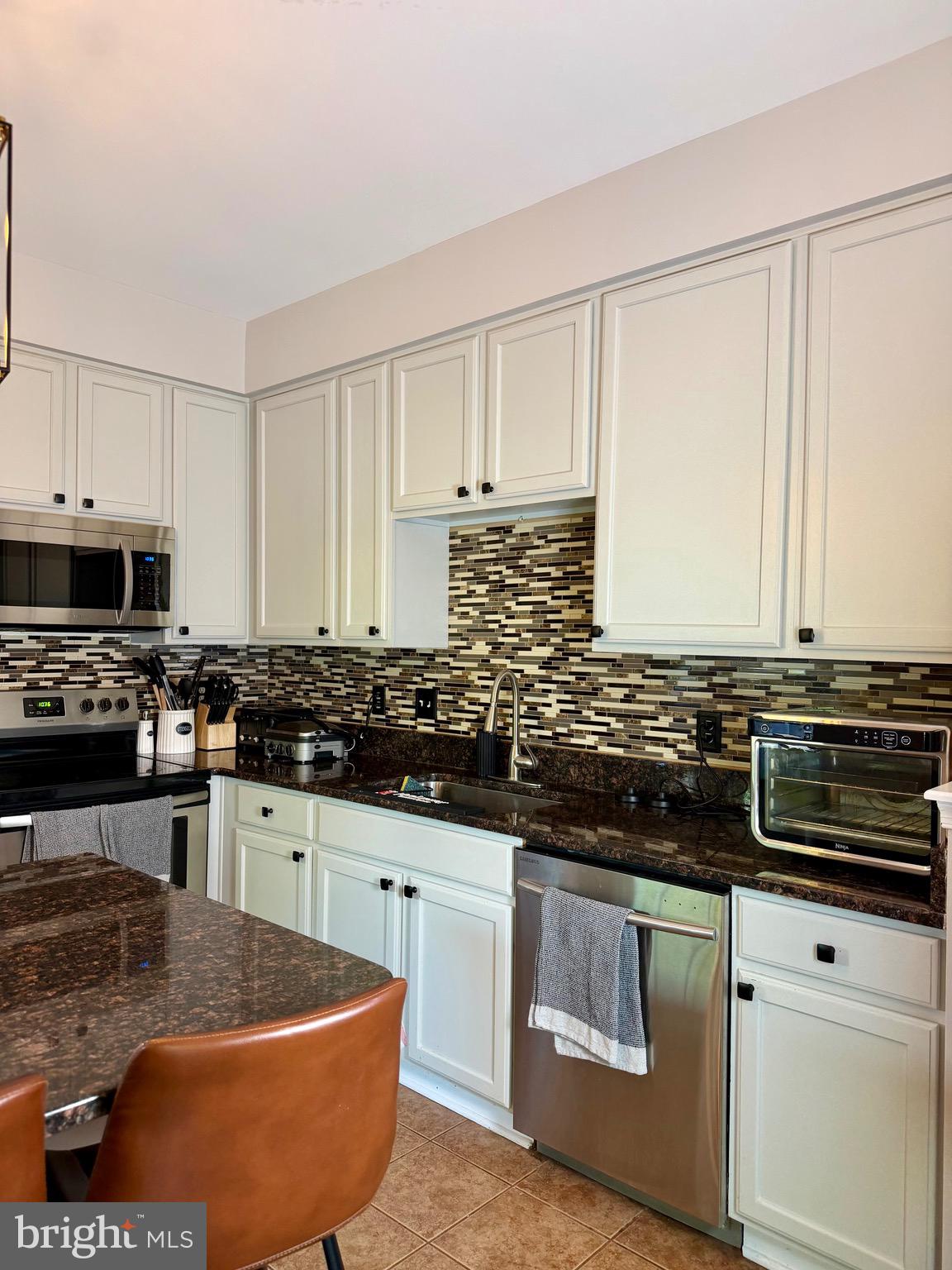 7108 Wheeling Way Gainesville, VA 20155 - Photo 13 of 45 a kitchen with stainless steel appliances granite countertop a sink stove and cabinets