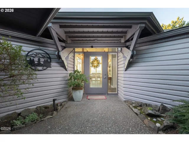 a living room with couches a dining table and chairs with chandelier