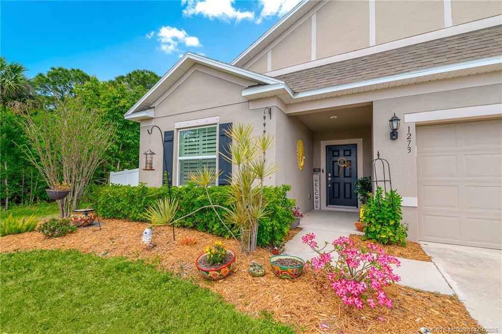 1273 Southwest Chase Road Port St. Lucie, FL 34953 - Photo 3 of 27 a front view of a house with garden