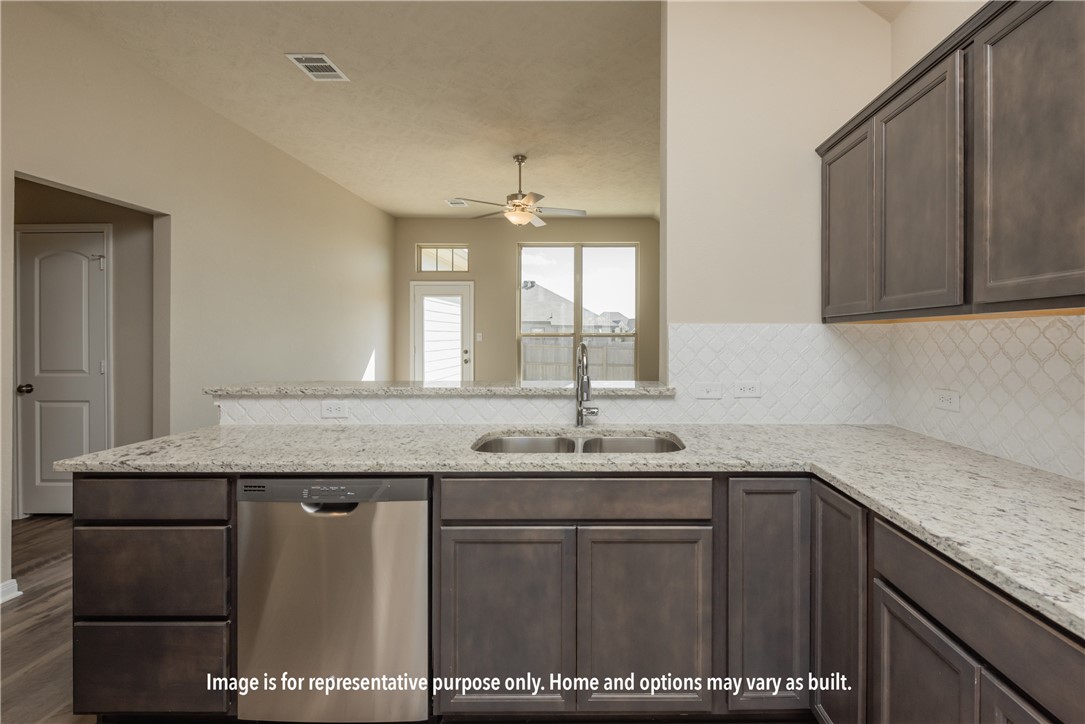 5685 Fox Blf Drive Bryan, TX 77807 - Photo 5 of 8 Kitchen featuring dark brown cabinetry, light stone countertops, stainless steel dishwasher, a peninsula, and decorative backsplash