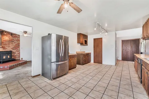 an empty room with windows and fireplace