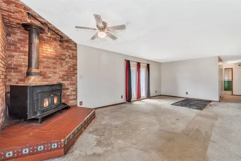 a view of an empty room with a fireplace and a window