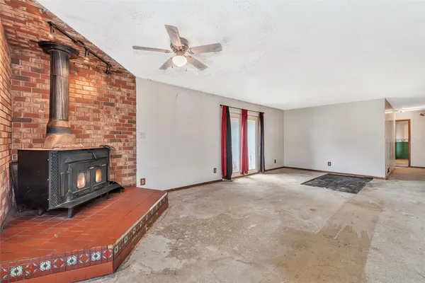 a view of an empty room with a fireplace and a window