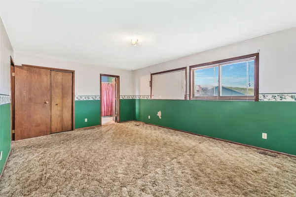 an empty room with windows and fan