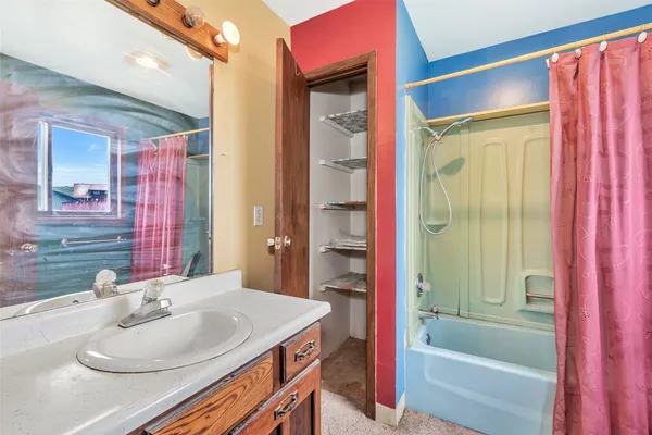 an empty room with chandelier fan and windows