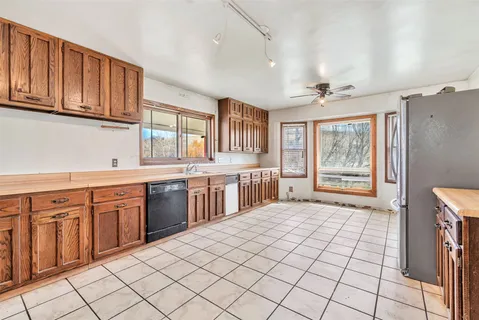 a large kitchen with stainless steel appliances granite countertop a sink and cabinets