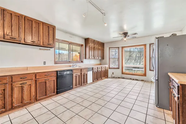 a large kitchen with stainless steel appliances granite countertop a sink and cabinets