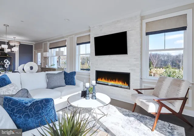 a kitchen with stainless steel appliances kitchen island granite countertop a dining table chairs and a refrigerator