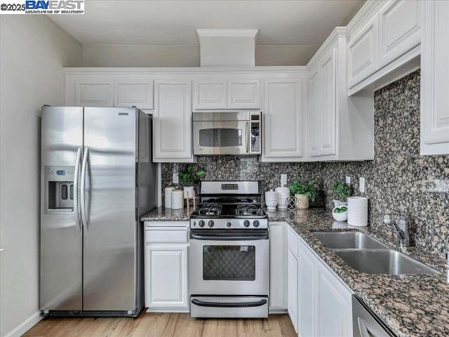 3275 Dublin Boulevard, Unit 408 Dublin, CA 94568 - Photo 4 of 52 a kitchen with stainless steel appliances granite countertop a refrigerator sink and microwave