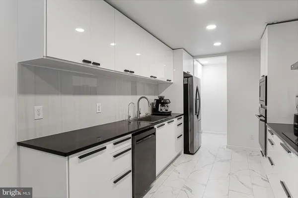 a kitchen that has a sink a stove and a refrigerator