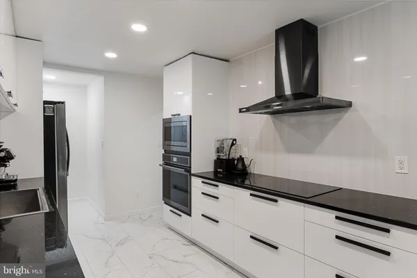 a kitchen with stainless steel appliances a refrigerator and a stove top oven