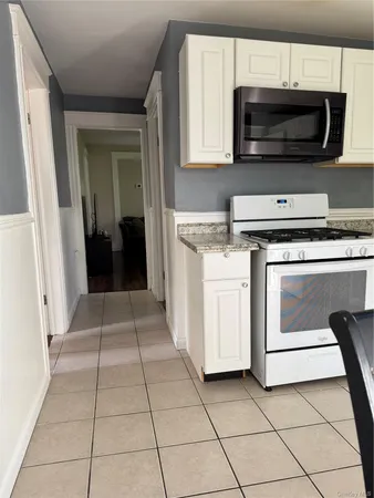 a kitchen with granite countertop a stove a microwave and a cabinets