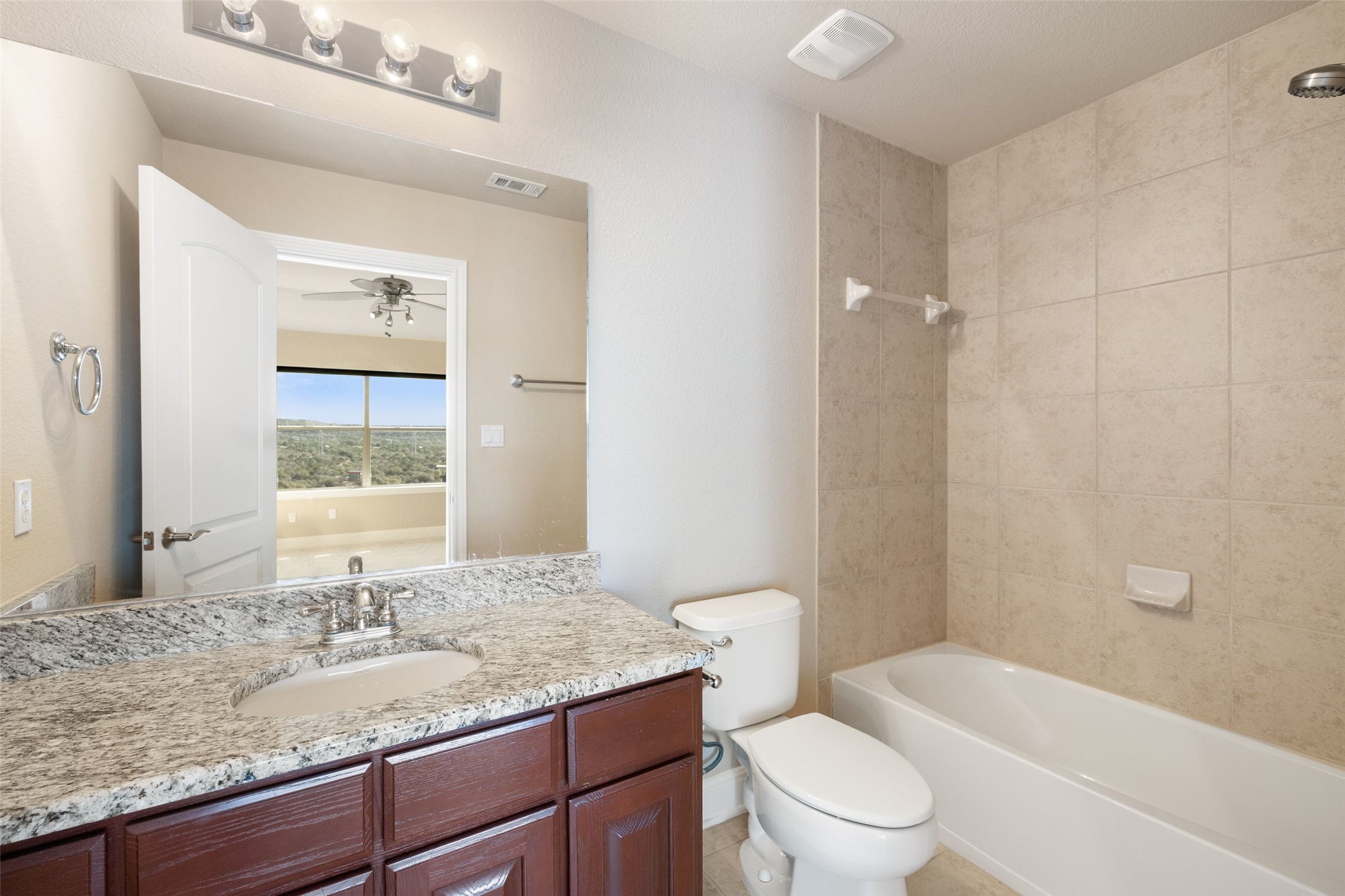 2702 Lakehurst Road Spicewood, TX 78669 - Photo 36 of 40 a bathroom with a granite countertop sink a toilet and shower