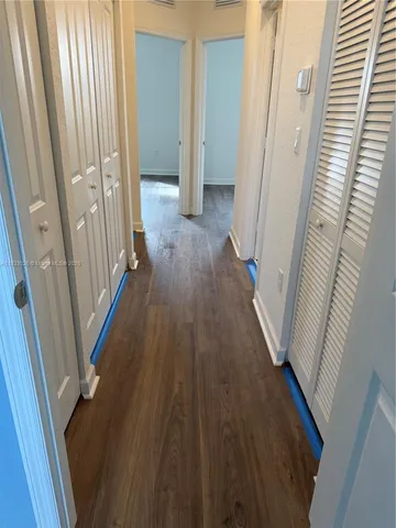 a view of a hallway with wooden floor and staircase