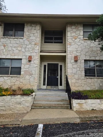 a stone house with potted plants in front of it