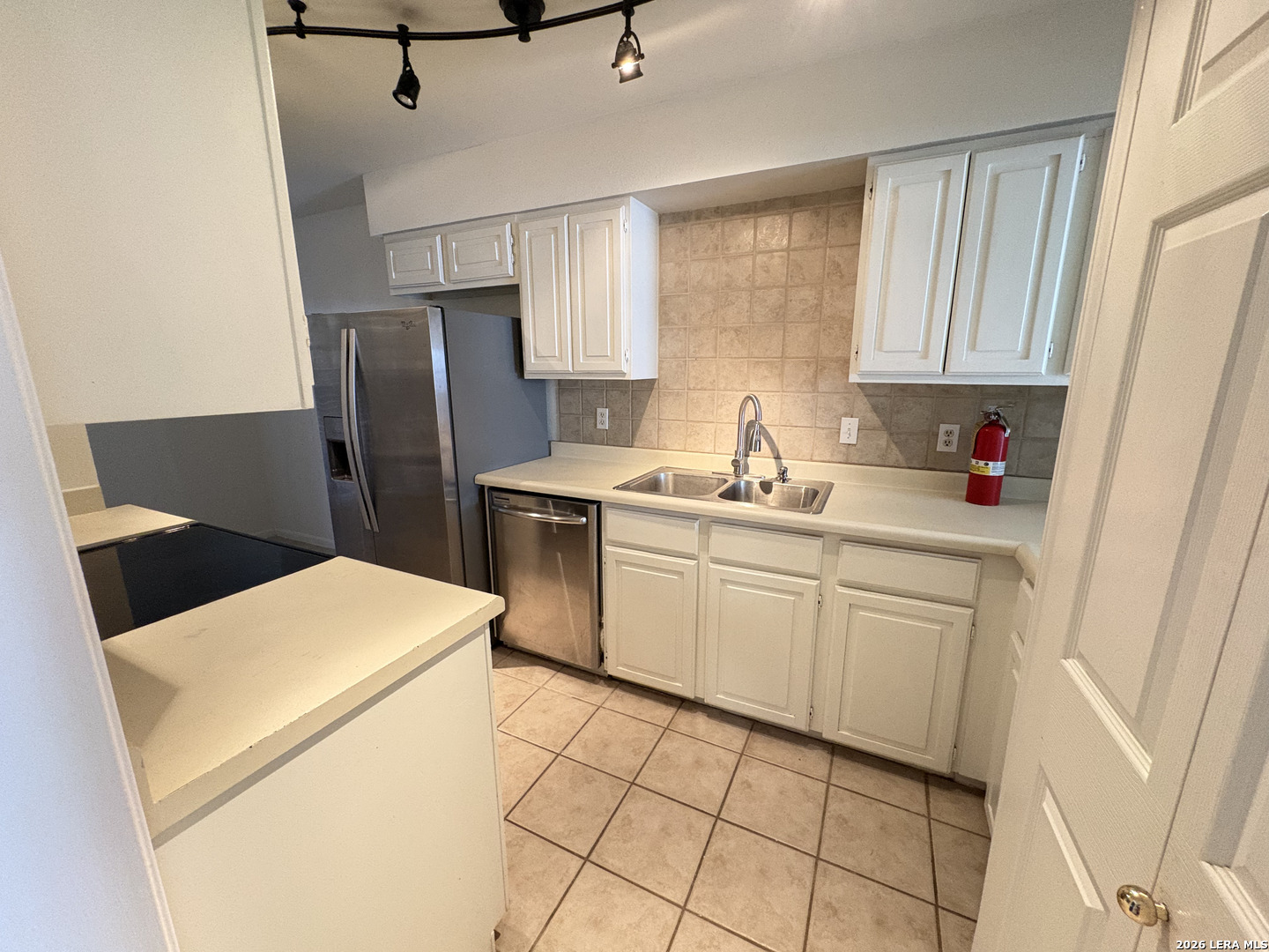 7738 Chambers Road, Unit 1101 San Antonio, TX 78229 - Photo 24 of 35 a kitchen with a sink a refrigerator and cabinets