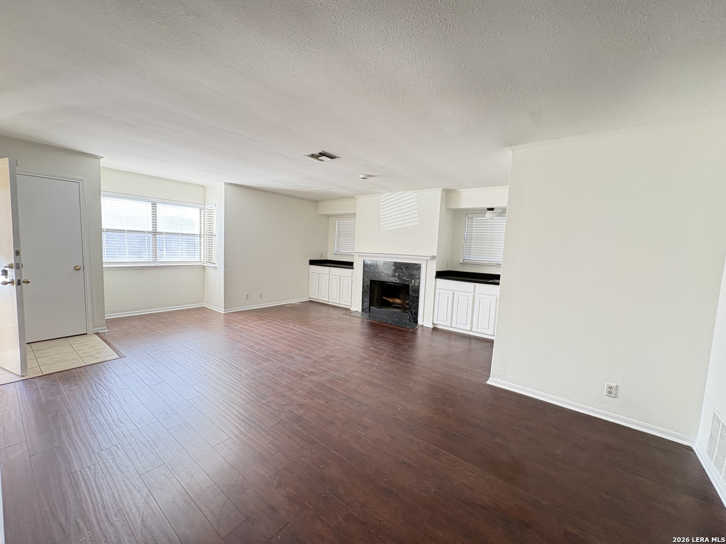 7738 Chambers Road, Unit 1101 San Antonio, TX 78229 - Photo 32 of 35 an empty room with wooden floor and kitchen view