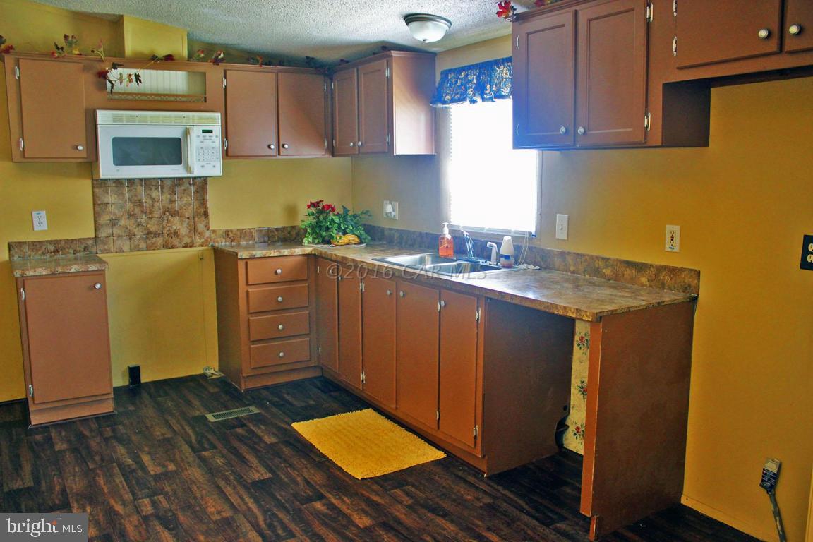 10841 Oriole Back Road Princess Anne, MD 21853 - Photo 3 of 12 a kitchen with granite countertop a sink stove and cabinets