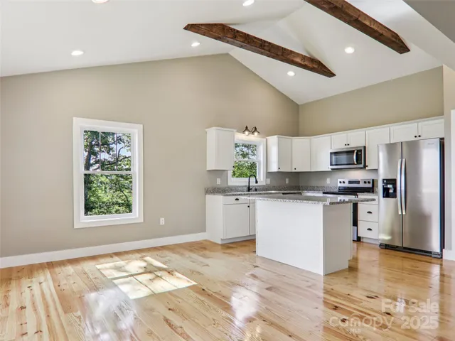 a large kitchen with stainless steel appliances granite countertop a stove a sink and a refrigerator