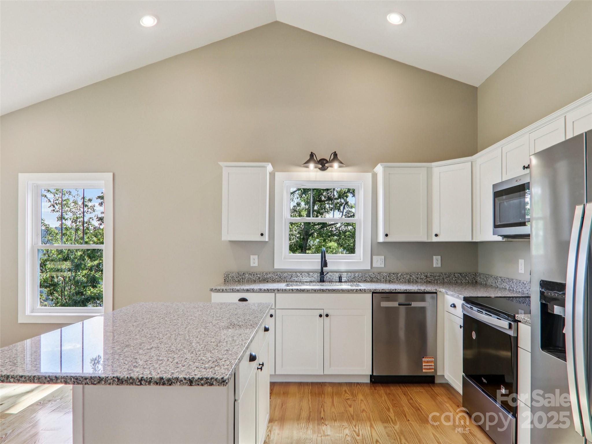 366 Ben Nevis Road Brevard, NC 28712 - Photo 14 of 48 a kitchen with stainless steel appliances granite countertop a sink stove and microwave