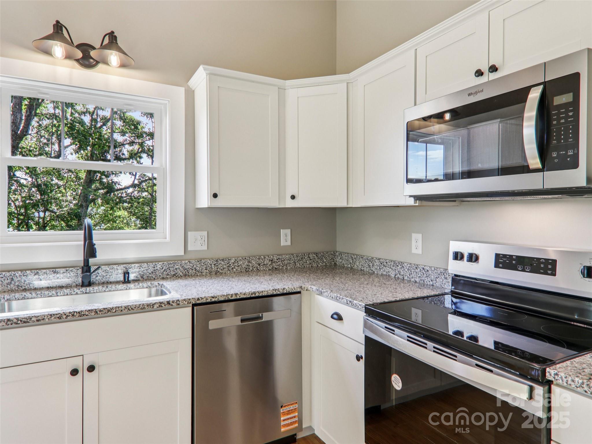 366 Ben Nevis Road Brevard, NC 28712 - Photo 17 of 48 a kitchen with stainless steel appliances granite countertop a stove microwave and cabinets