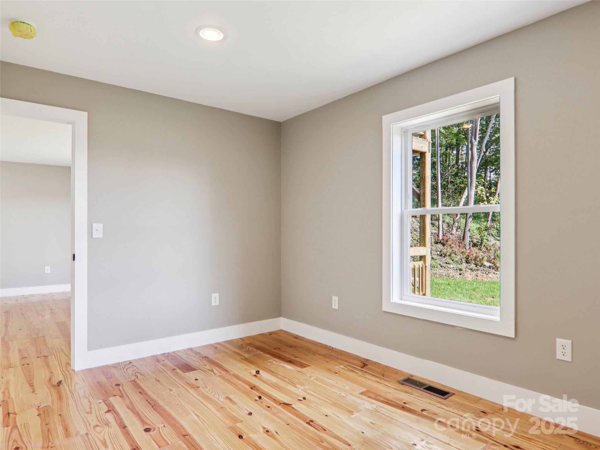 366 Ben Nevis Road Brevard, NC 28712 - Photo 33 of 48 a view of an empty room with wooden floor and a window