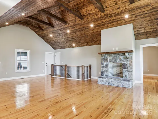 a view of a livingroom with wooden floor and a fireplace
