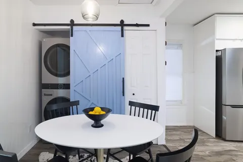 a bathroom with a sink a table and chairs
