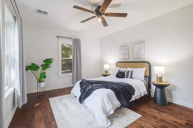 a bedroom with a bed lamp and a potted plant