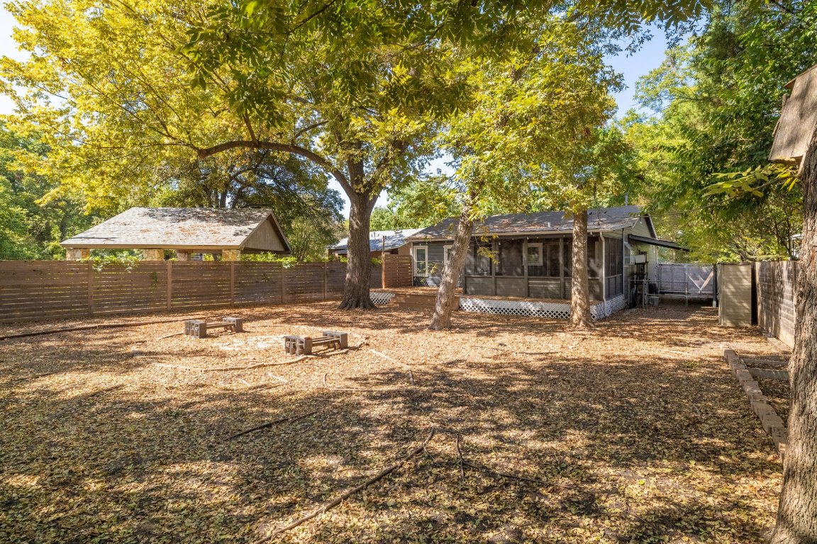6511 Chesterfield Avenue Austin, TX 78752 - Photo 23 of 27 a backyard of a house with table and chairs under an umbrella