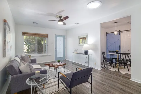 a living room with furniture a wooden floor and a window