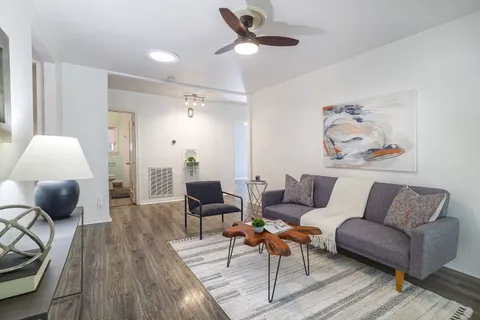 a living room with furniture and a wooden floor