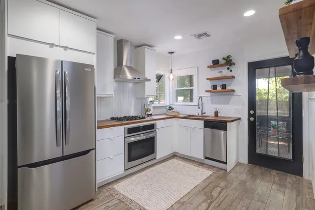 a kitchen with stainless steel appliances a refrigerator sink and cabinets